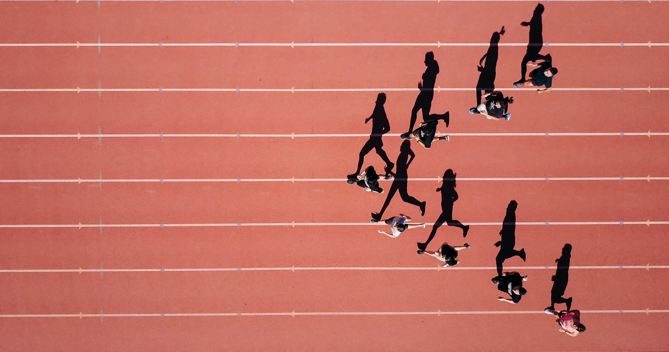 Top-down view of a group of people runnning in a running track