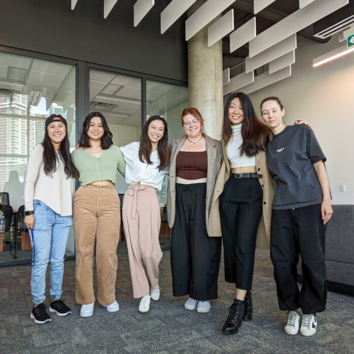 This photo is of the creators of Seedling Art Co. There are six people together smiling for the camera.