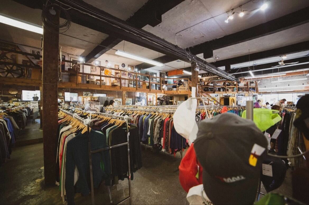 The interior of a store with a large selection of clothing.