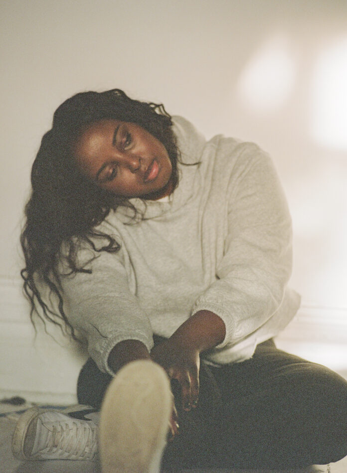 Image 2 Maryam Said sits against a white background looking to the side.