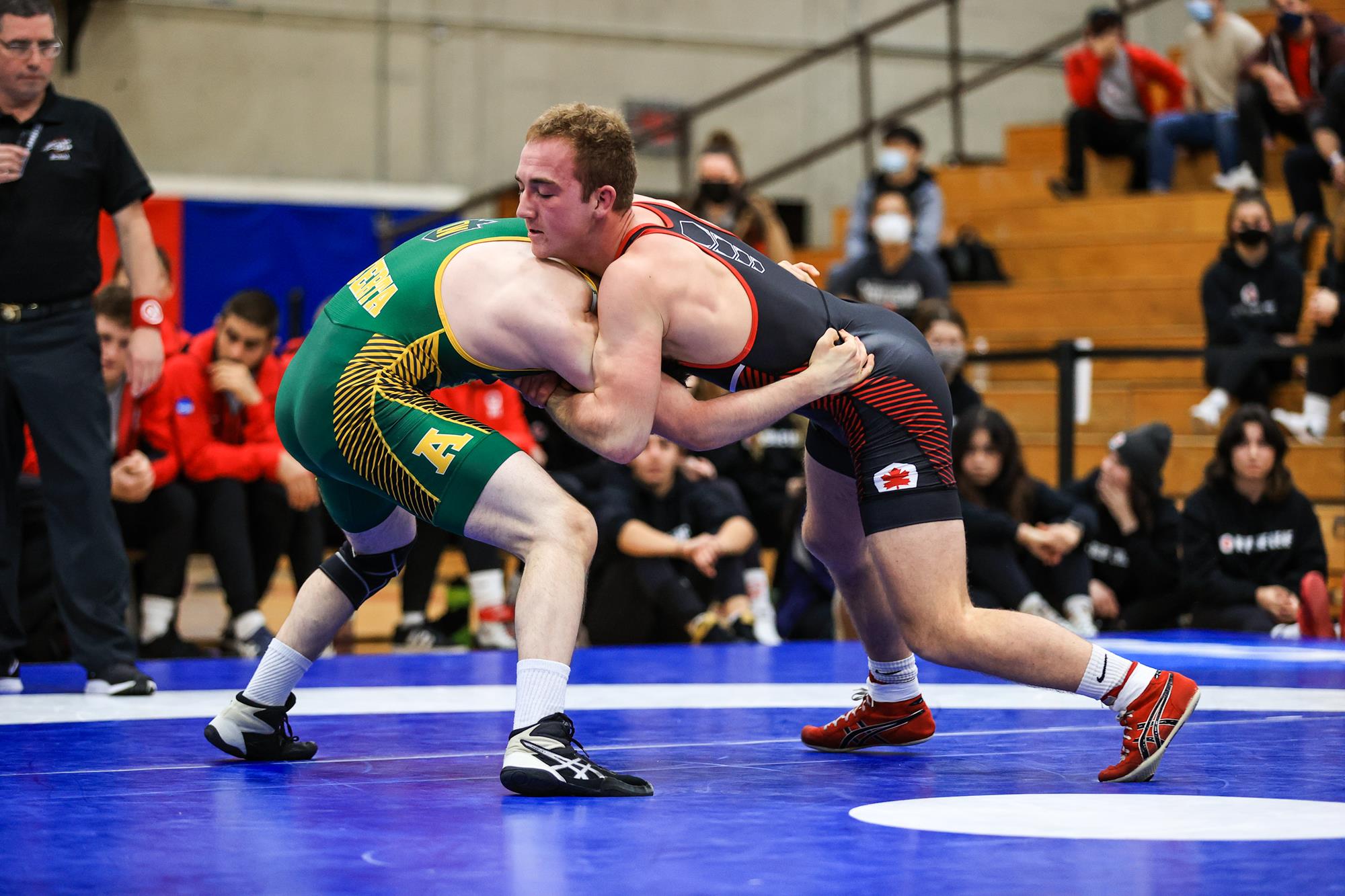 An SFU wrestling athlete captured in a body lock versus an opponent.