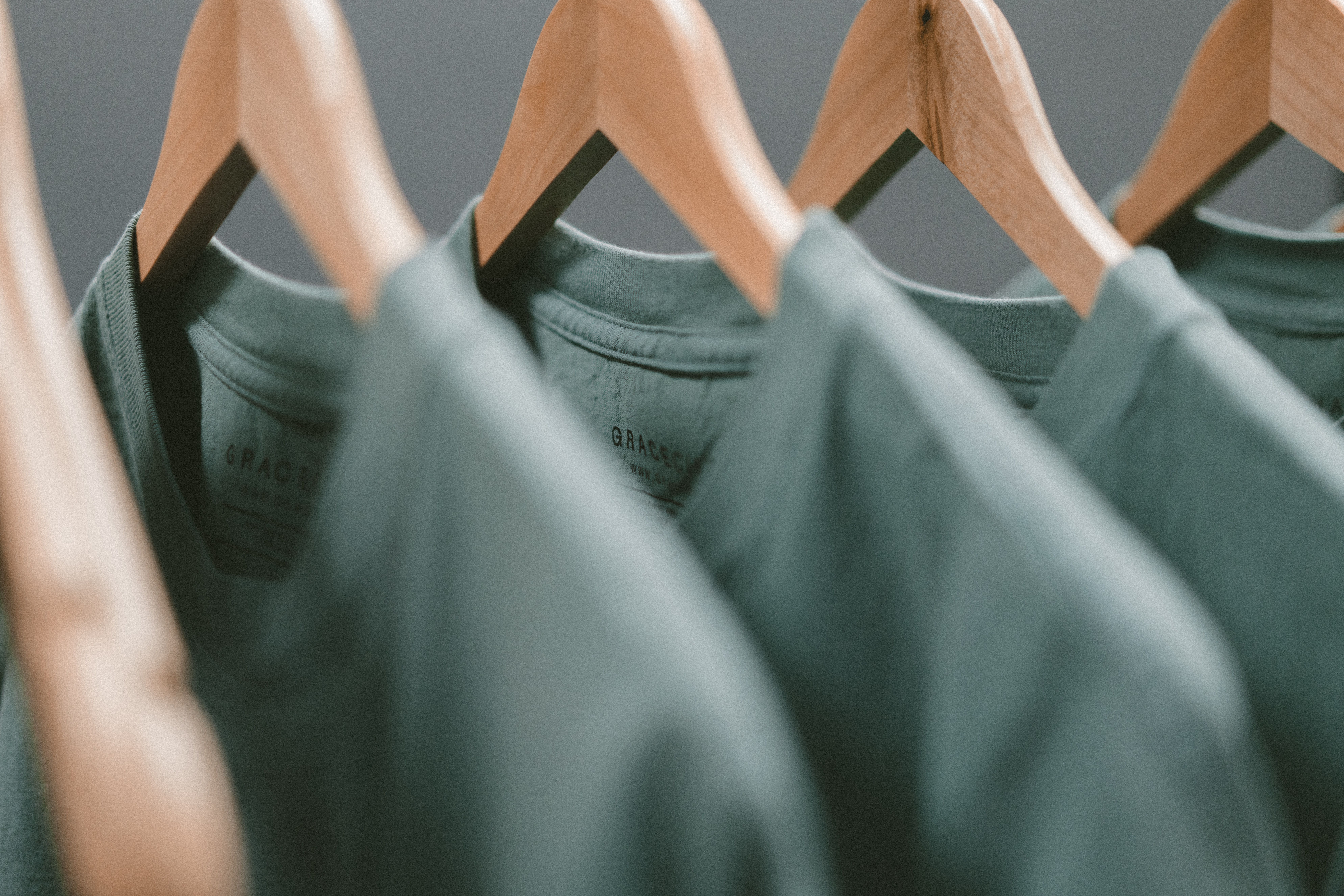 multiple green shirts on cloth hangers