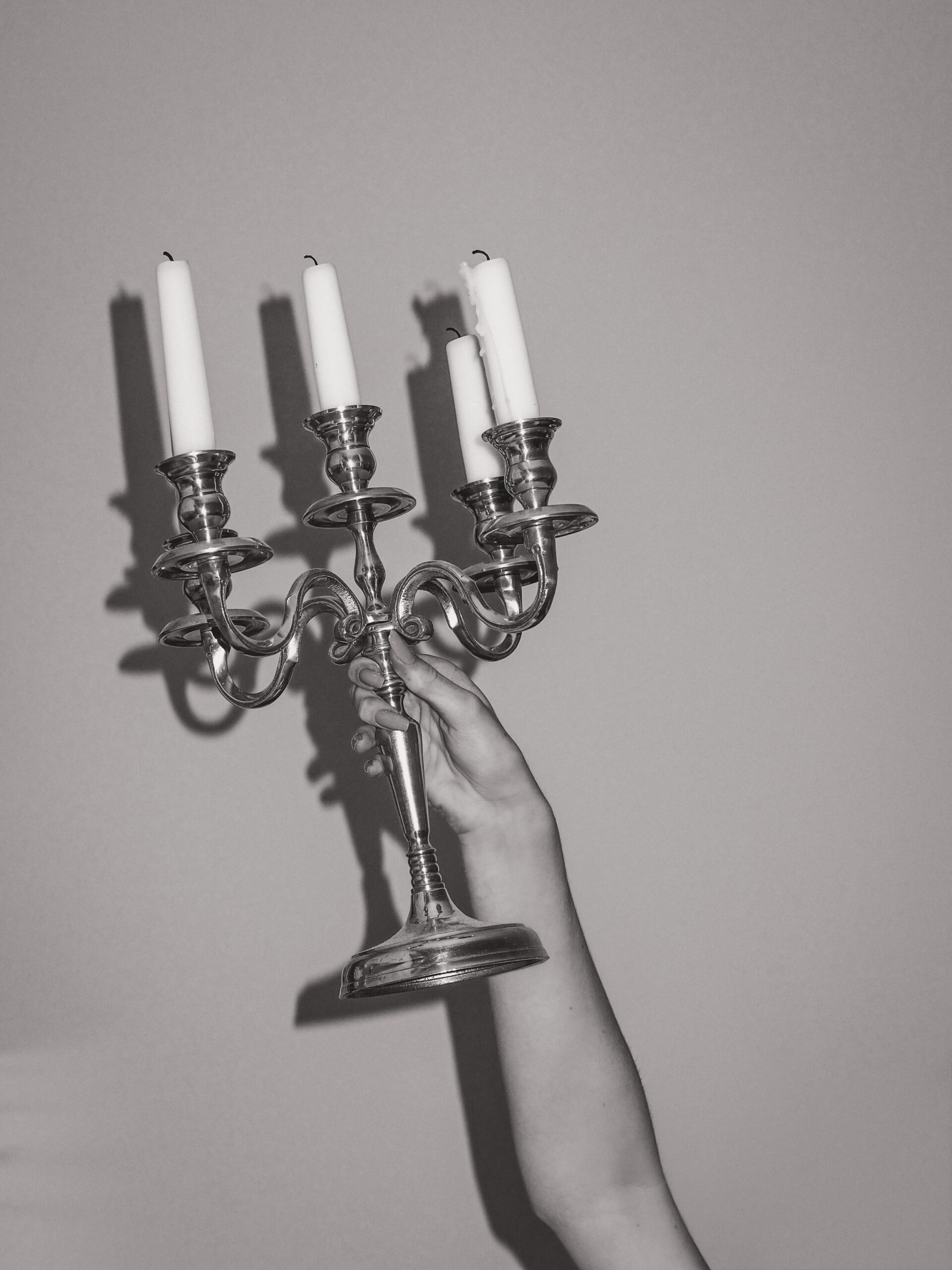 Photo of someone holding a candelabra in dim lighting.