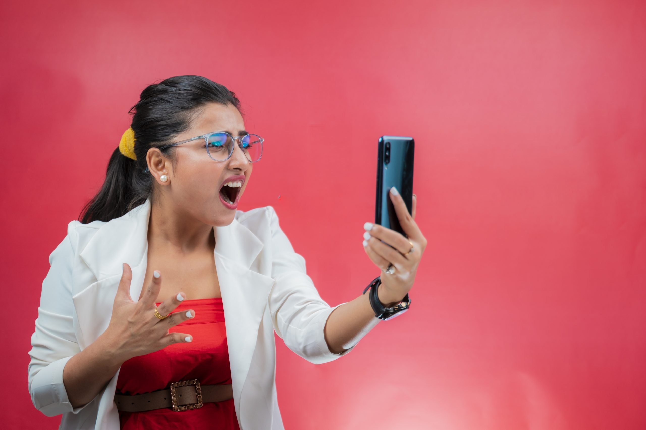 A photo of a woman looking shocked at her phone