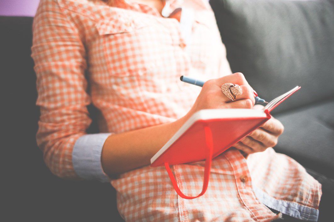 A photo of a woman writing in a diary.