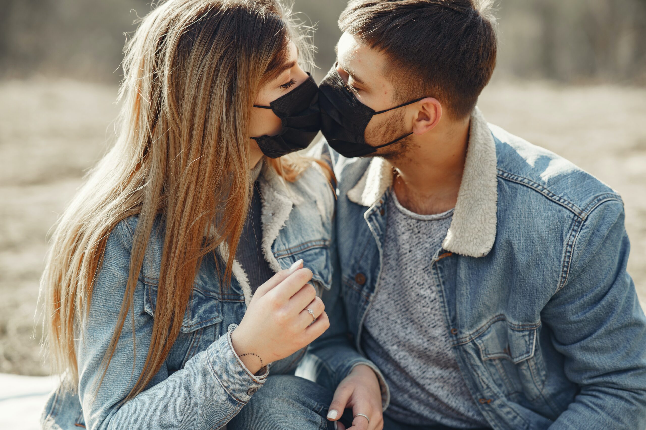 This is a photo of two people kissing each other through the face masks they are wearing.
