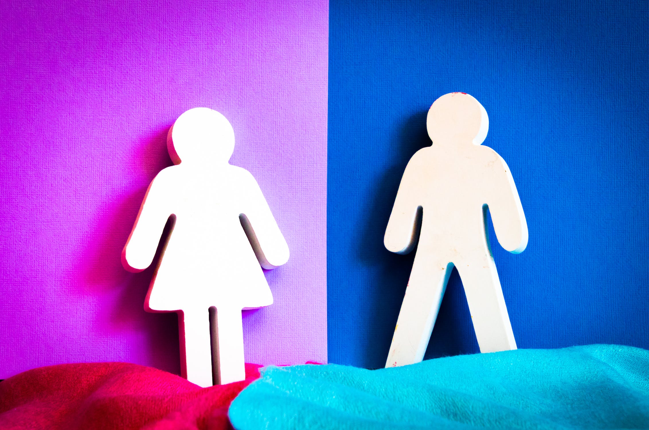 A graphic of two male and female symbols divided into a pink and blue background