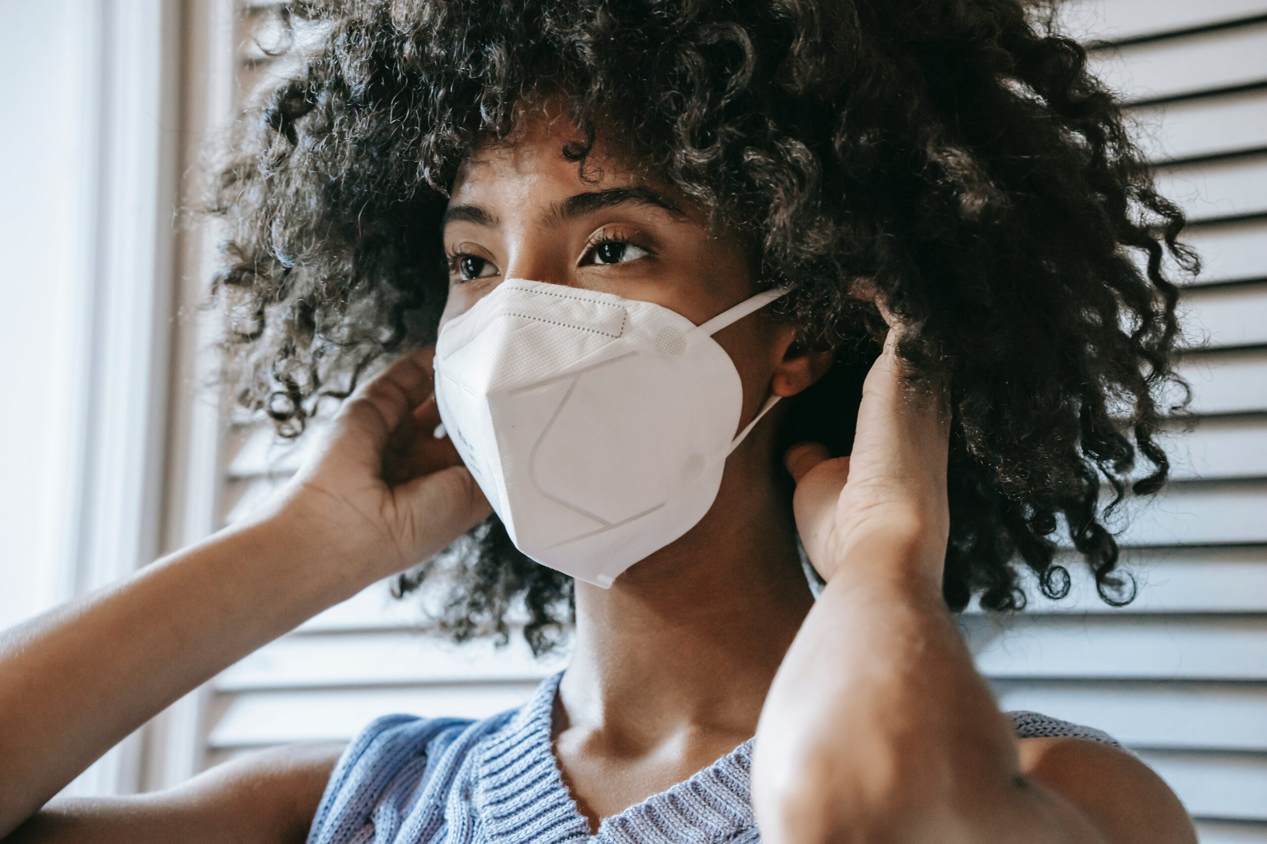 Photo of a woman putting on respirator