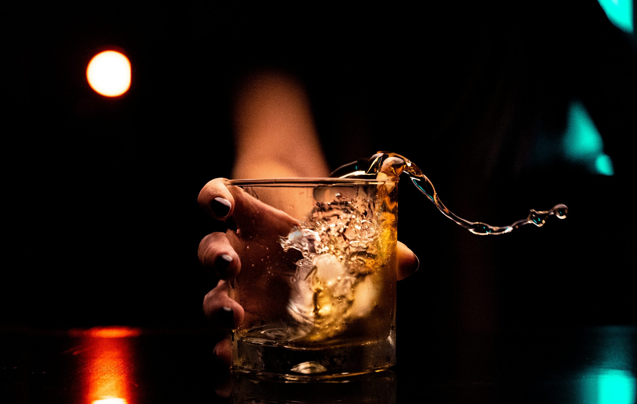 Drinking glass with splashing alcohol