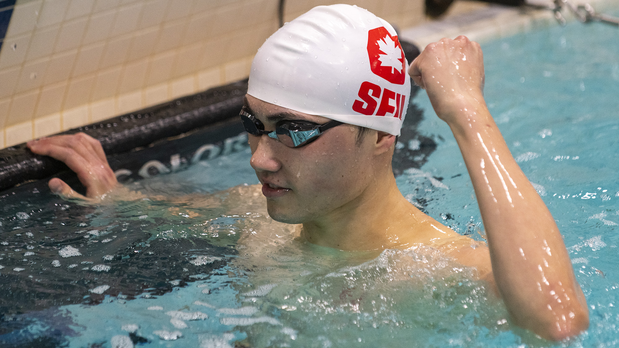 Photo of an SFU swimmer celebrating in the water.