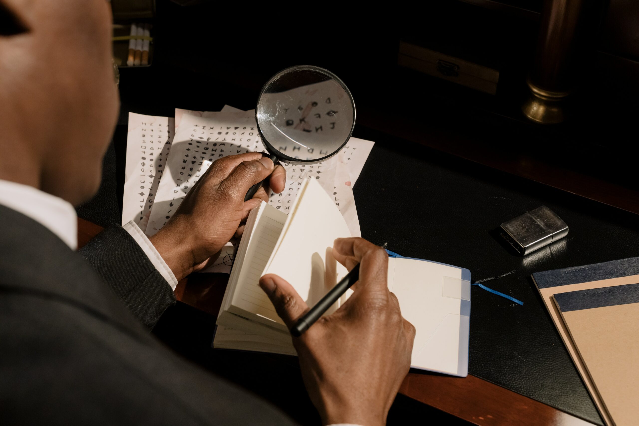 Black and white image of a student looking at the camera with a magnifying glass.