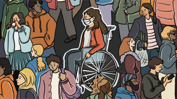 a crowd of unmasked people with one masked person in a wheelchair in the middle
