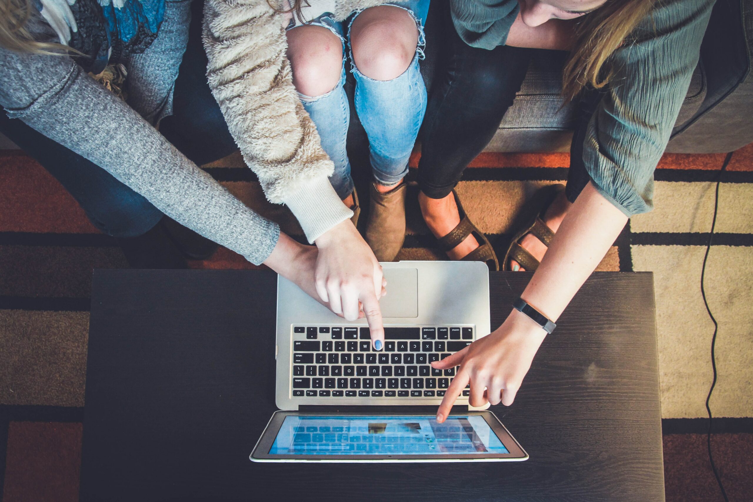 Aerial shot of multiple people pointing at a computer screen.