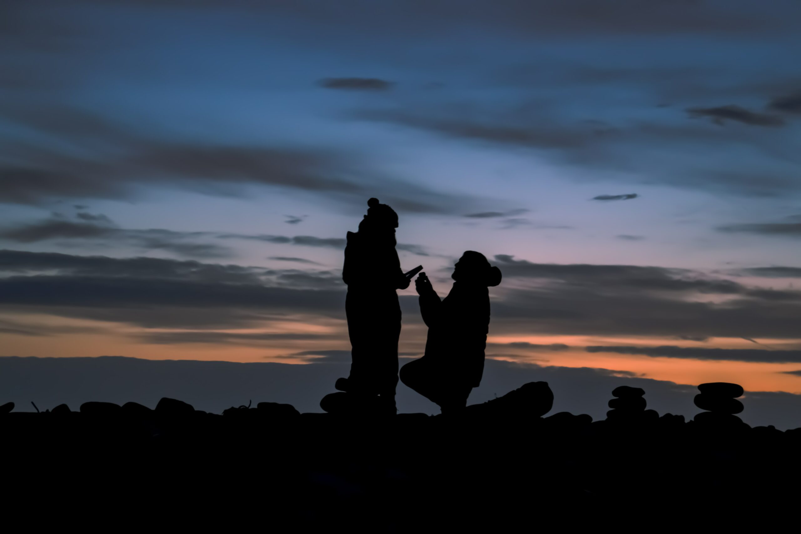 a sunset proposal on a rocky hilltop