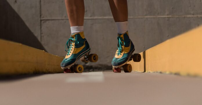A photo of a person of color in roller skates. No clear location of where the photo was taken.