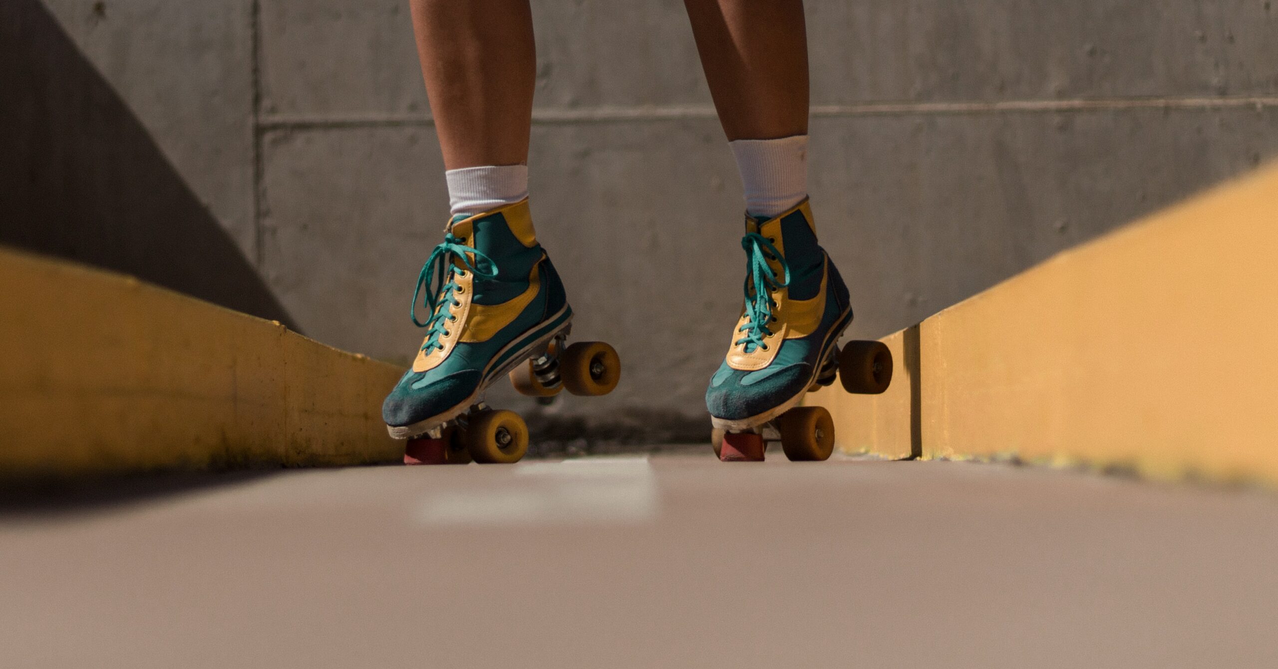 A photo of a person of color in roller skates. No clear location of where the photo was taken.