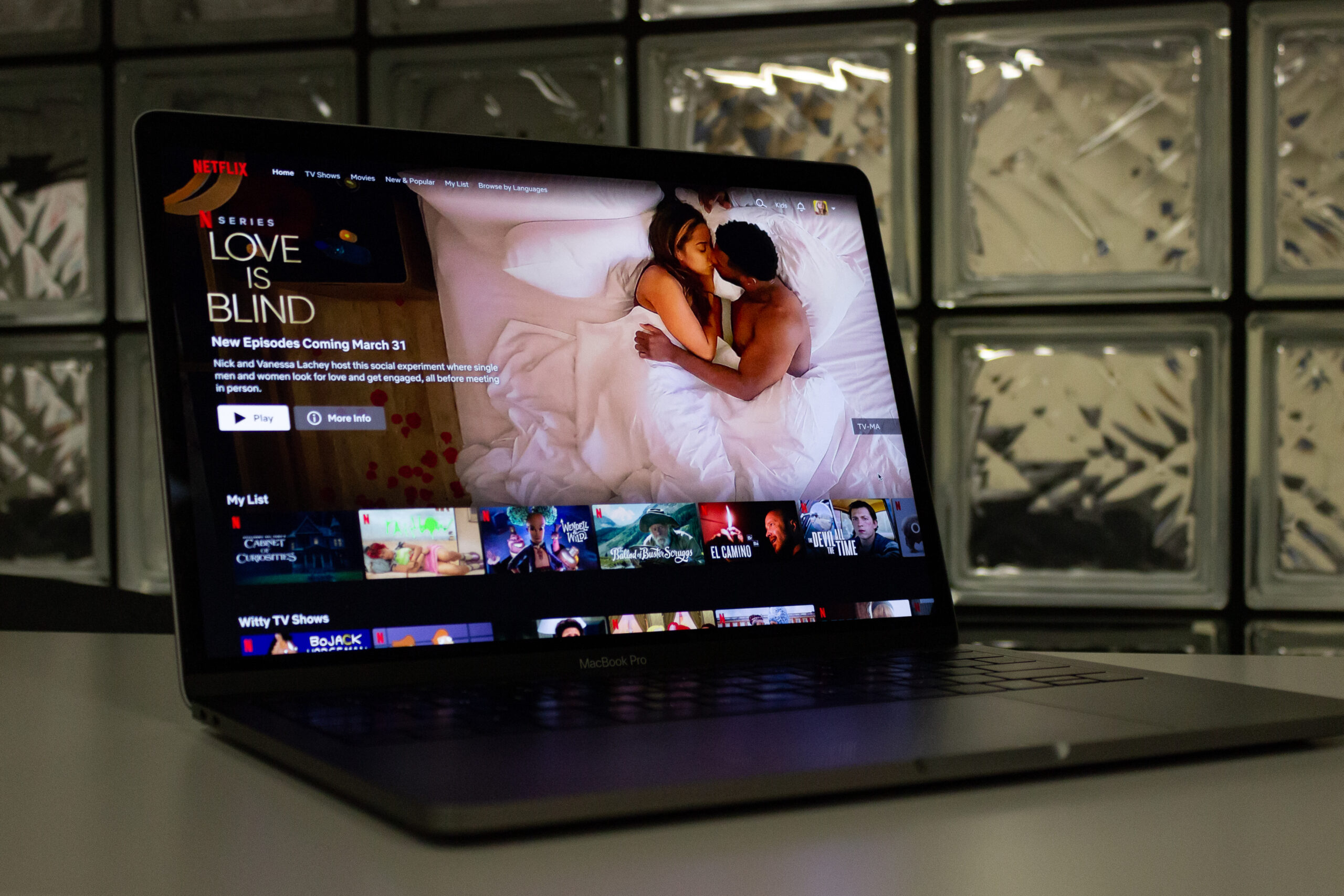 laptop on a table open to Netflix’s home screen, with “Love is Blind” featured at the top