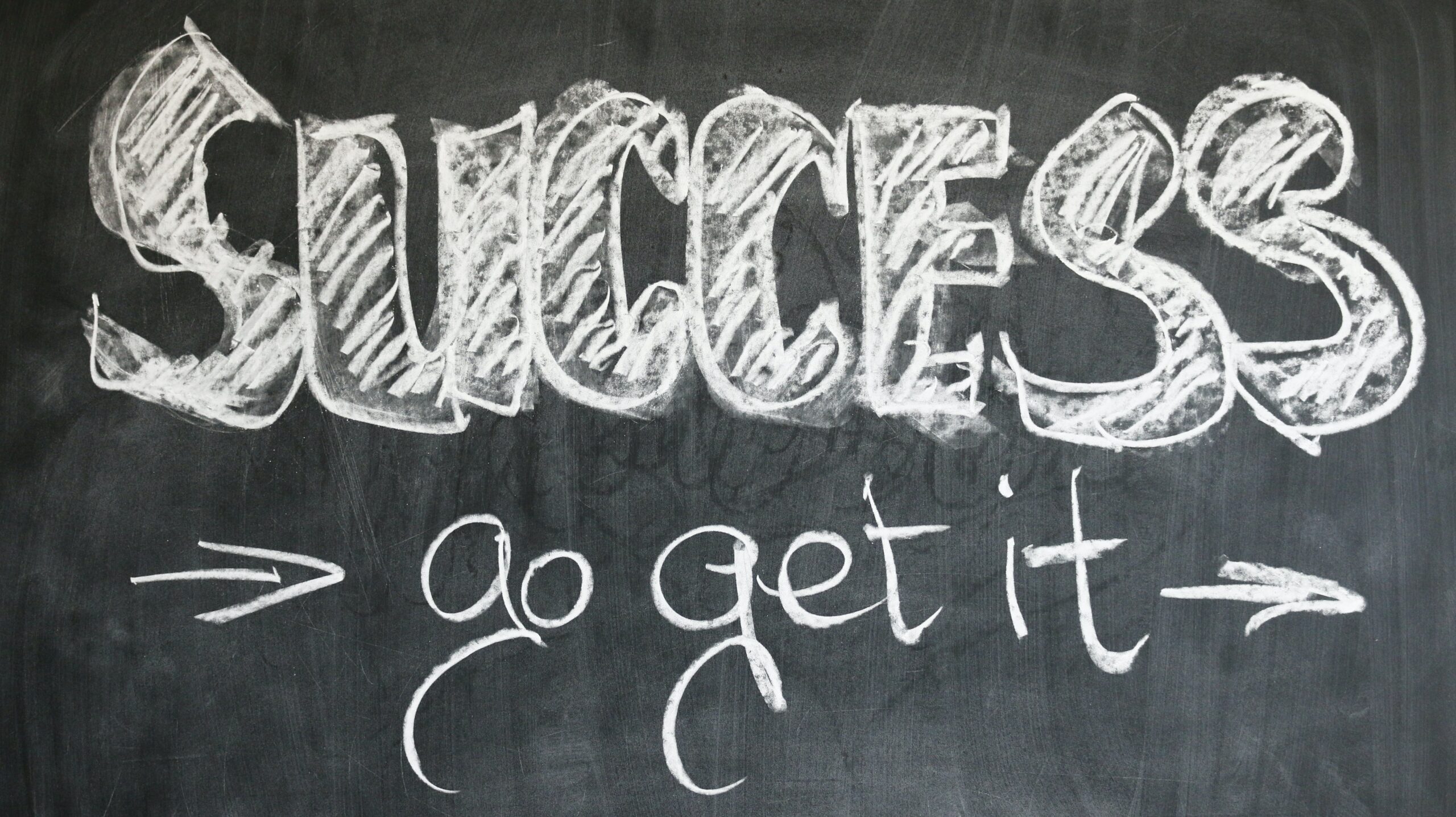 A blackboard with “SUCCESS go get it” written on it with white chalk