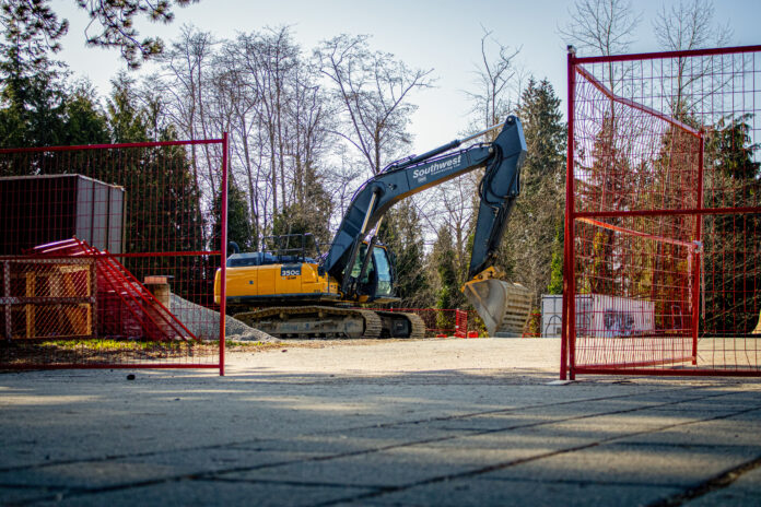 This is a photo of the construction site for the First Peoples’ Gathering House. An excavator is sitting on the ground scoping dirt.