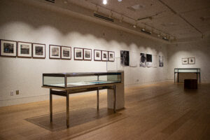 Photo of the spacious room of an exhibit. Framed photographs line the walls.