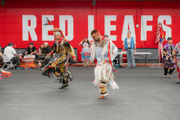 Photograph of two of the dancers in formal regalia at the powwow event on April 8, 2022.