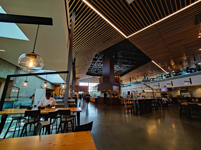 dining-commons This is a photo of the SFU Dining Hall. People are buying food and walking around the space.