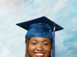 In photo, Des'ree Isibor in a blue graduation gown and red details holding a diploma