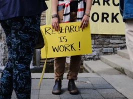 A sign reading "research is work"
