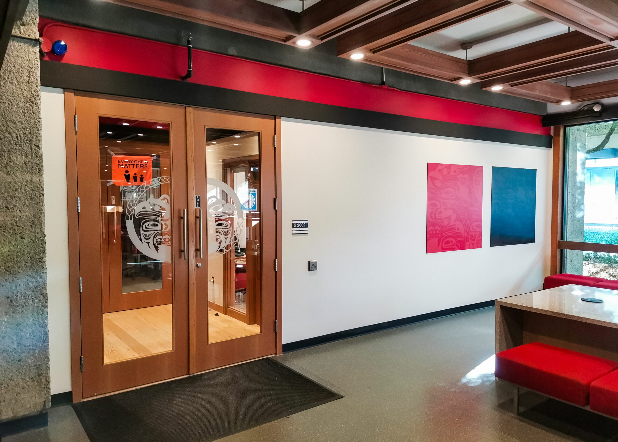 This is a photo of the Indigenous Student Centre on the SFU Burnaby campus. The doors to the office are shown, their name is printed on the door.