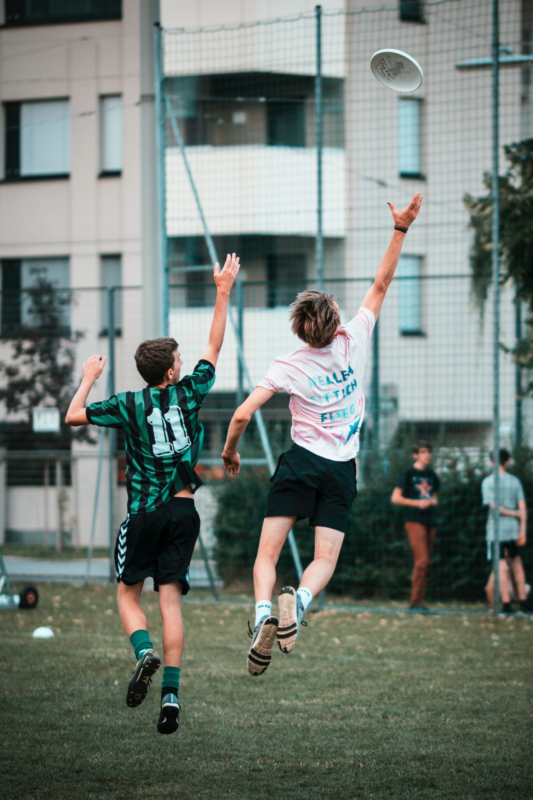 Photo of two people jumping in the air to catch a frisbee