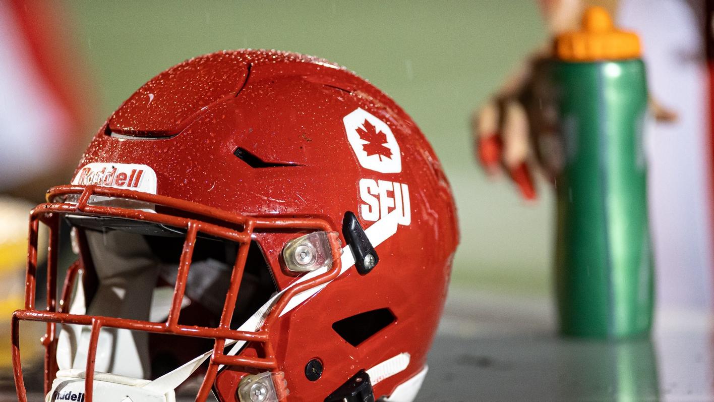 Photo of an SFU football helmet in the rain.