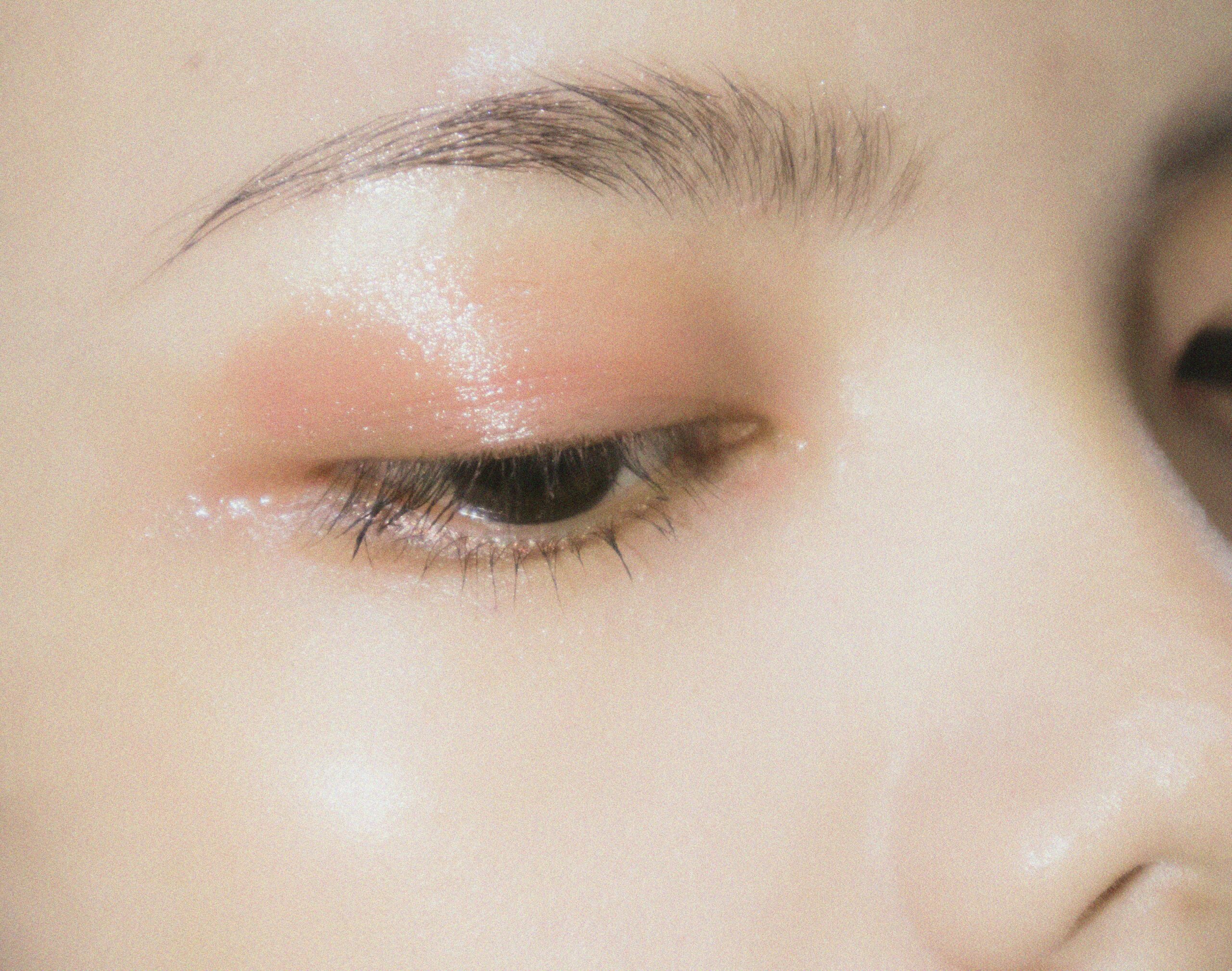 Close-up of an eye, with shimmery pink eye shadow and mascara