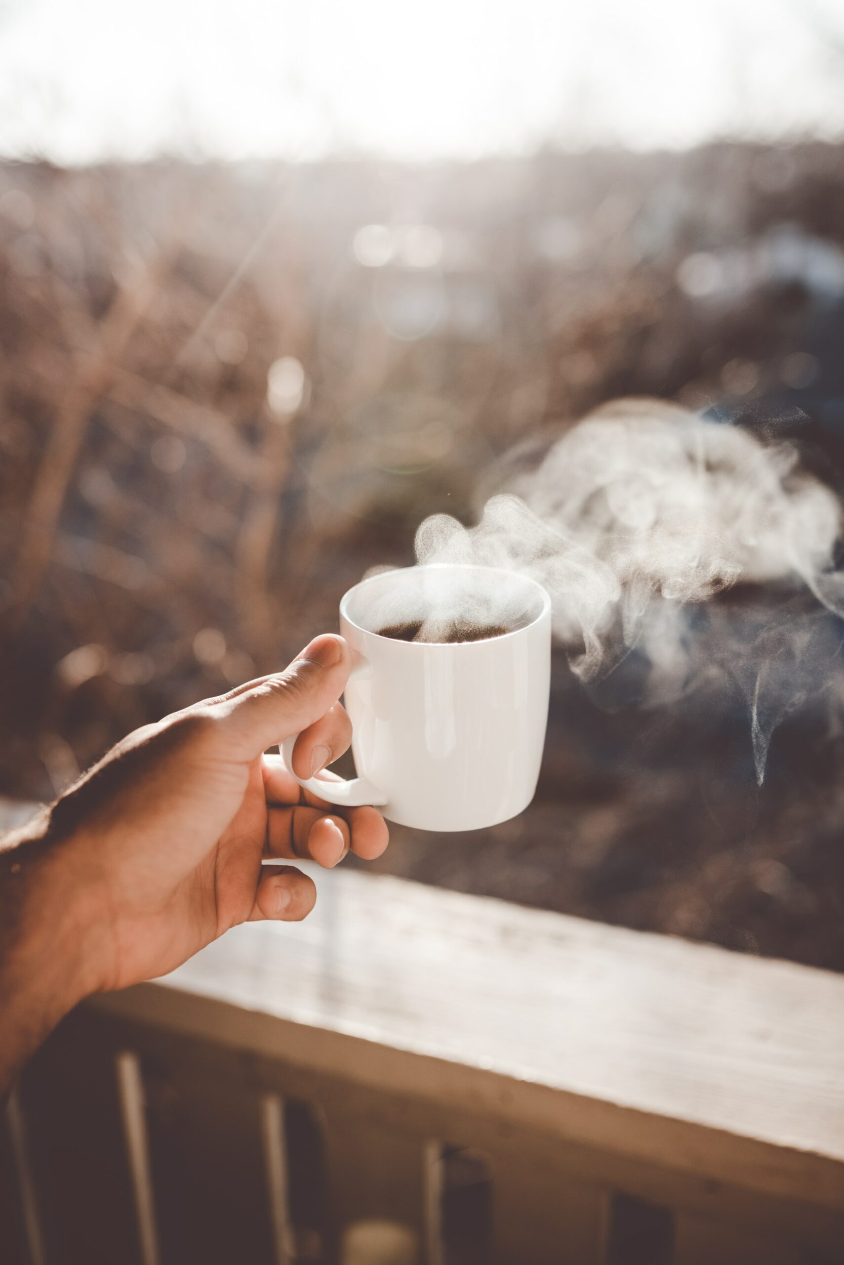 A white mug full of steamy coffee.