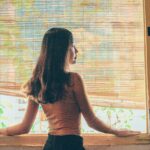 A chat with our favourite advice columnist A woman standing beside a window. The blinds are slightly raised.