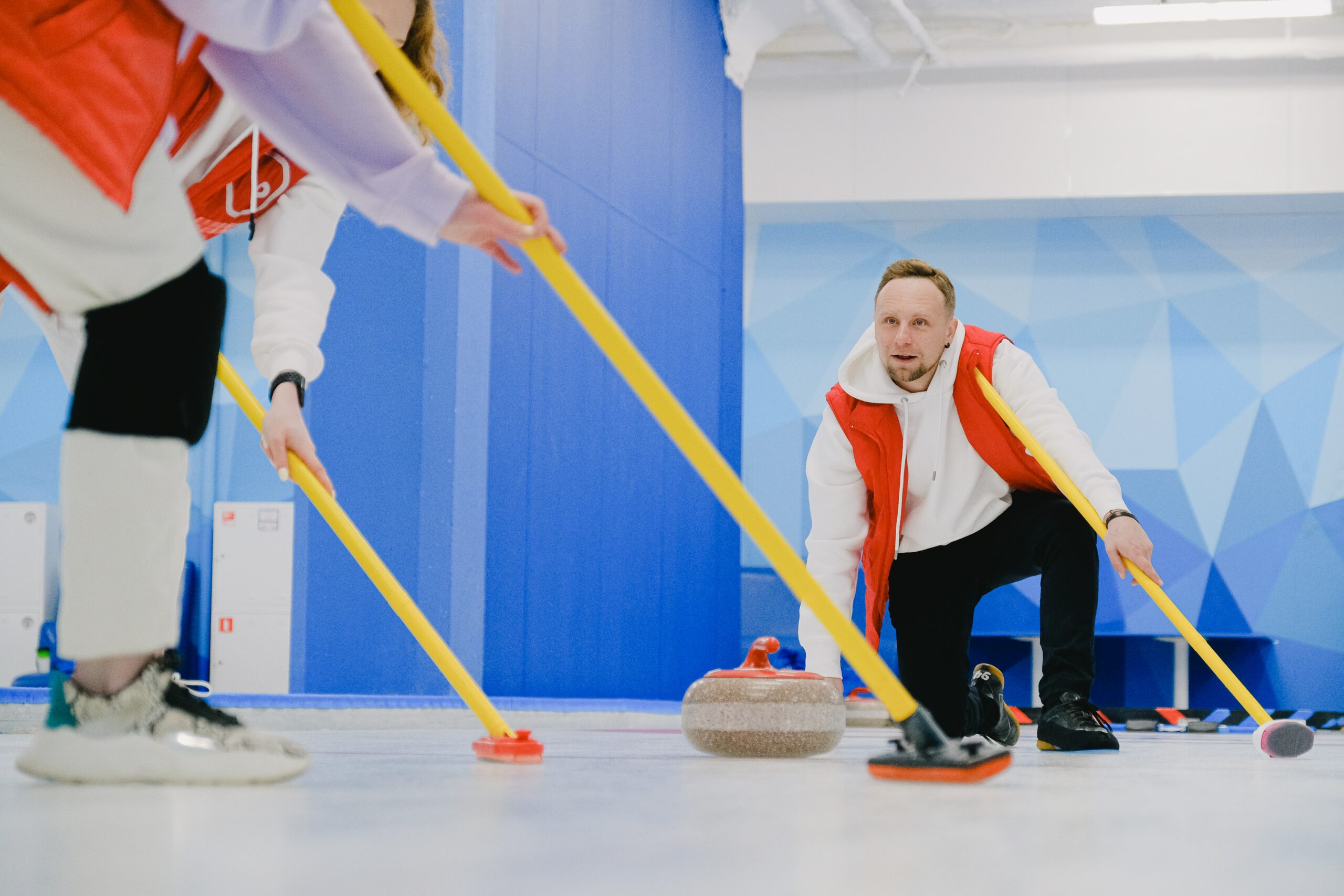 A photo of two players curling across the ice.