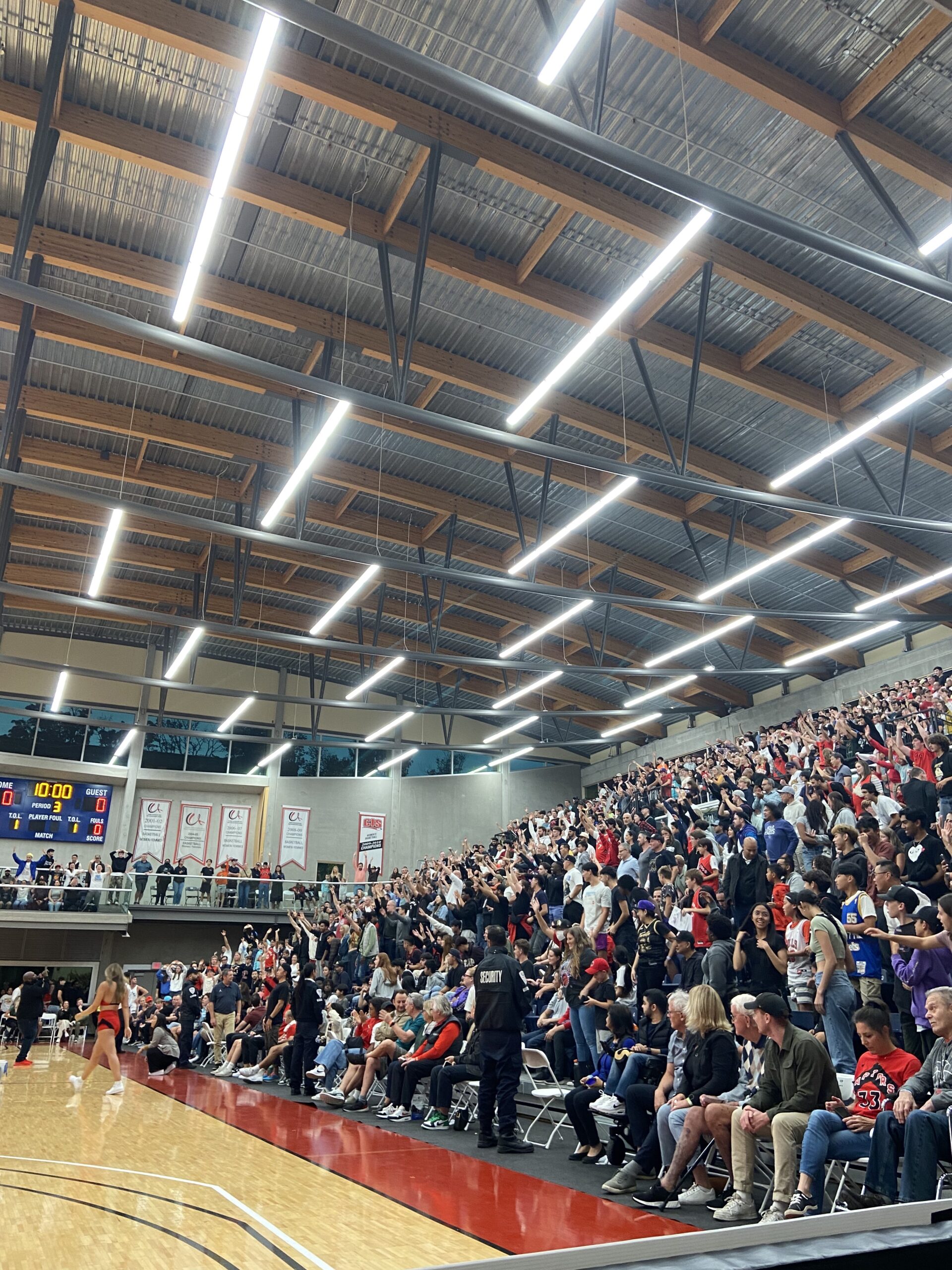 Pictured, the right side of the basketball court at SFU. Fans raise their arms up in anticipation.