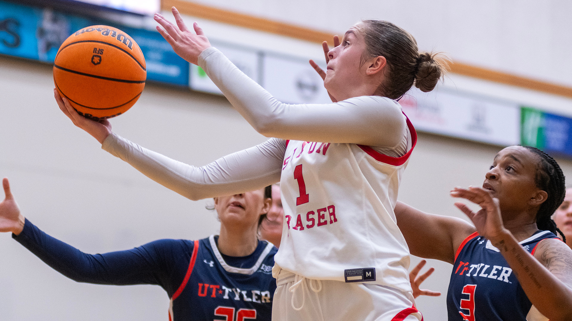 photo of an SFU basketball player under pressure at the hoop.