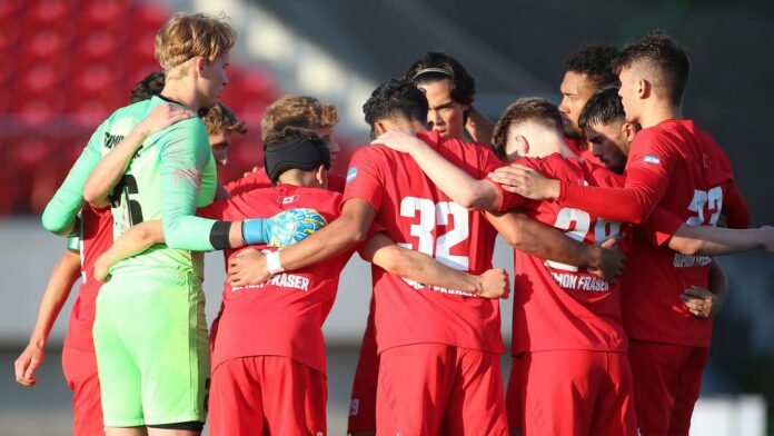 photo of the men’s soccer team in the middle of a huddle.