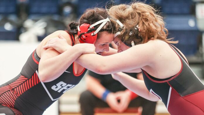 photo of an SFU wrestler in a headlock with an opponent.
