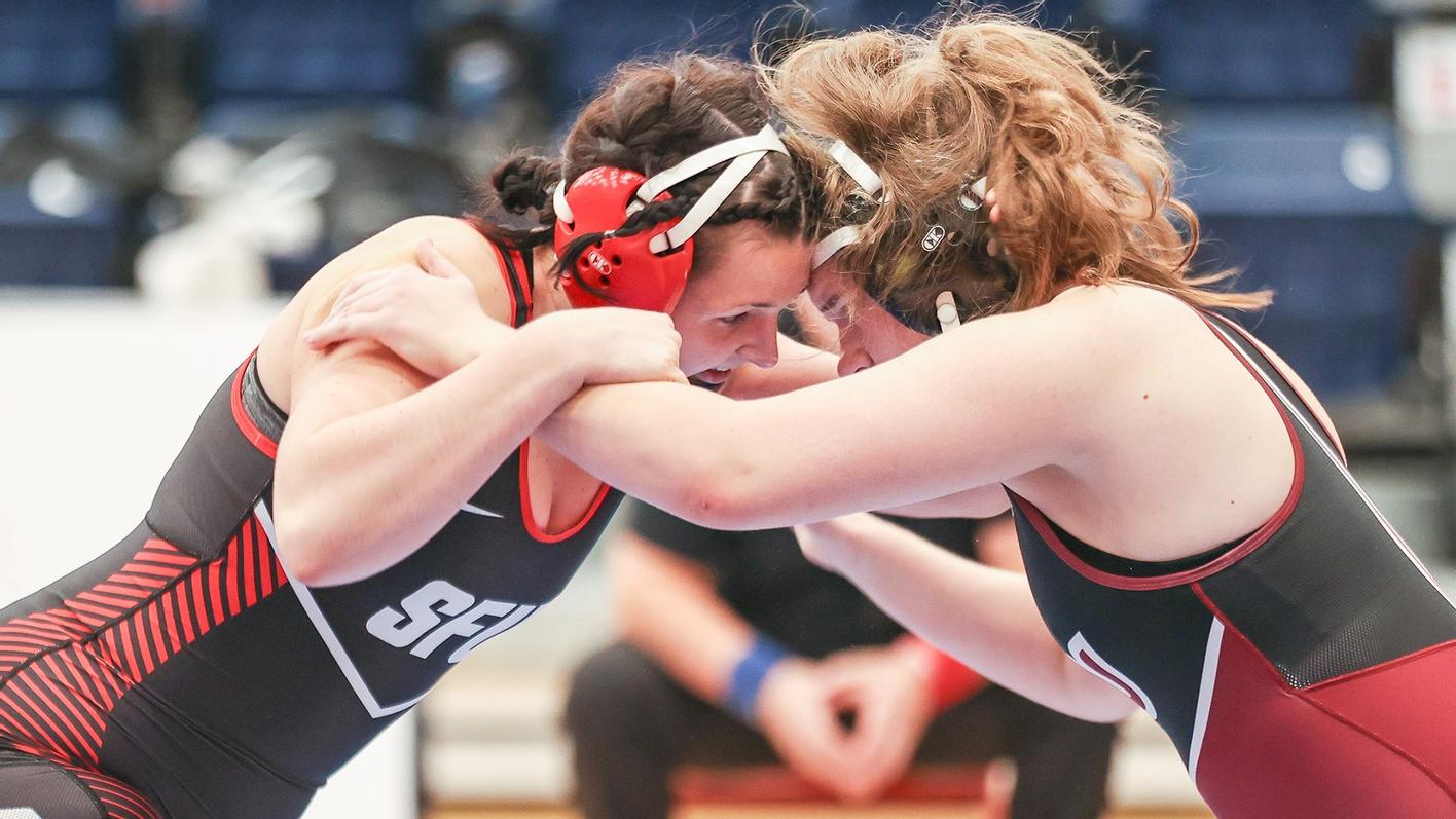 photo of an SFU wrestler in a headlock with an opponent.