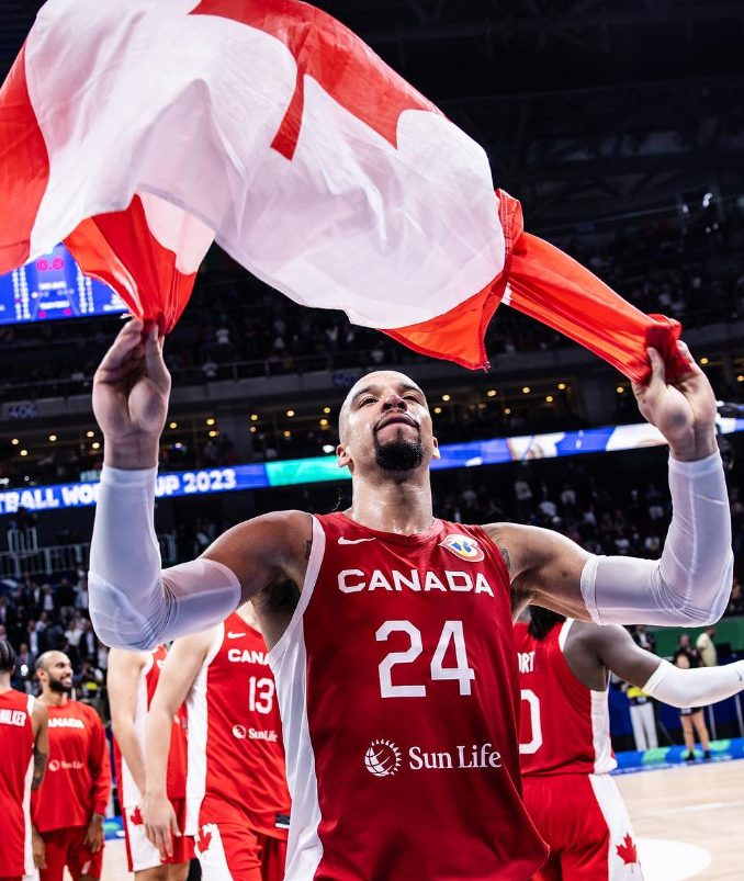 Team Canada basketball member Dillon Brooks celebrating with the Canadian flag after a game.