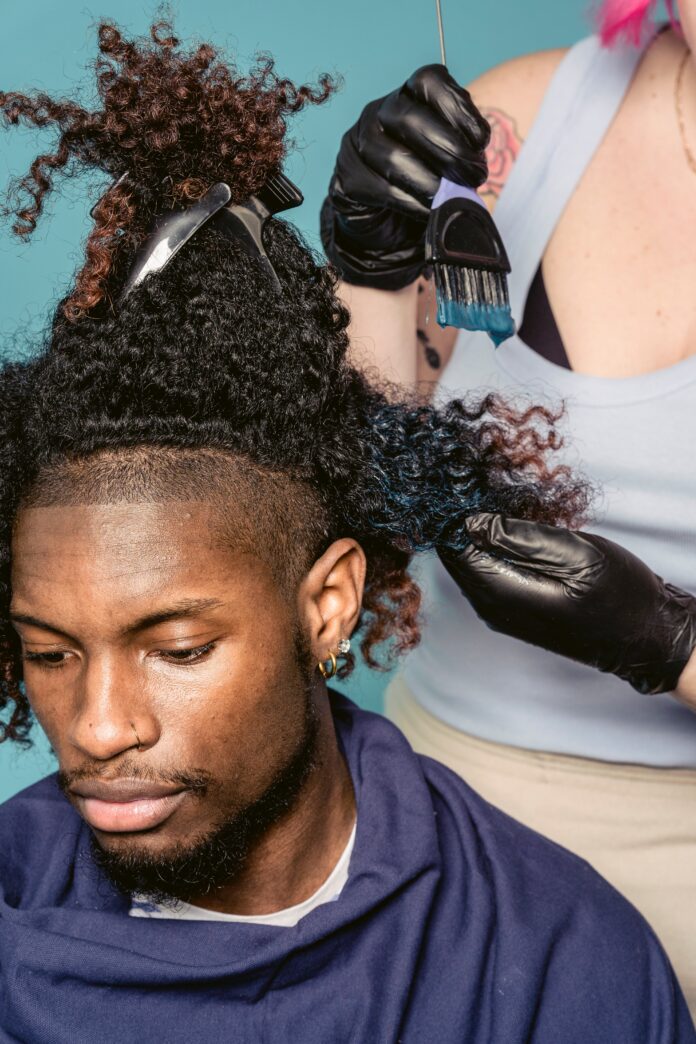 Man getting his hair dyed at a salon.