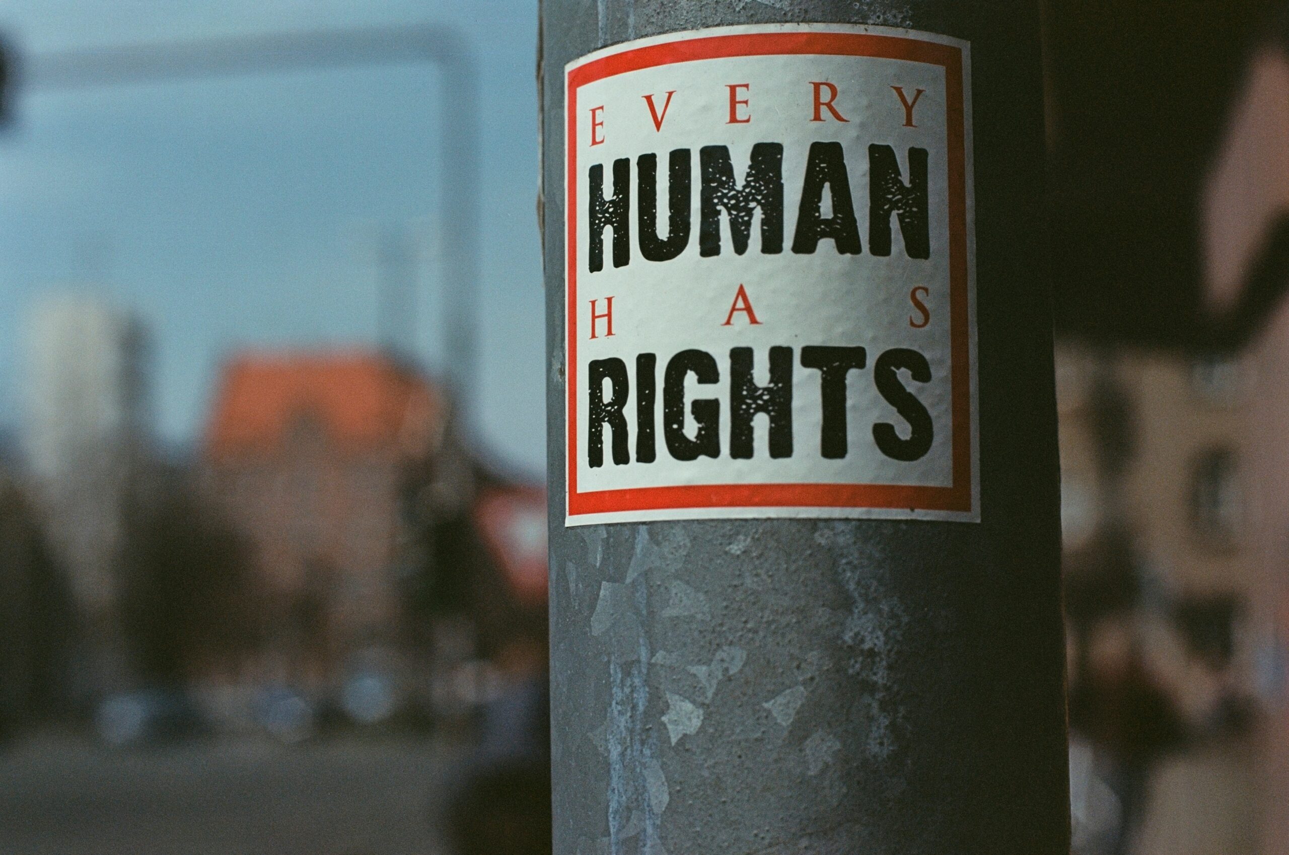 Photograph of a street post with a poster in it saying “Every Human has rights”