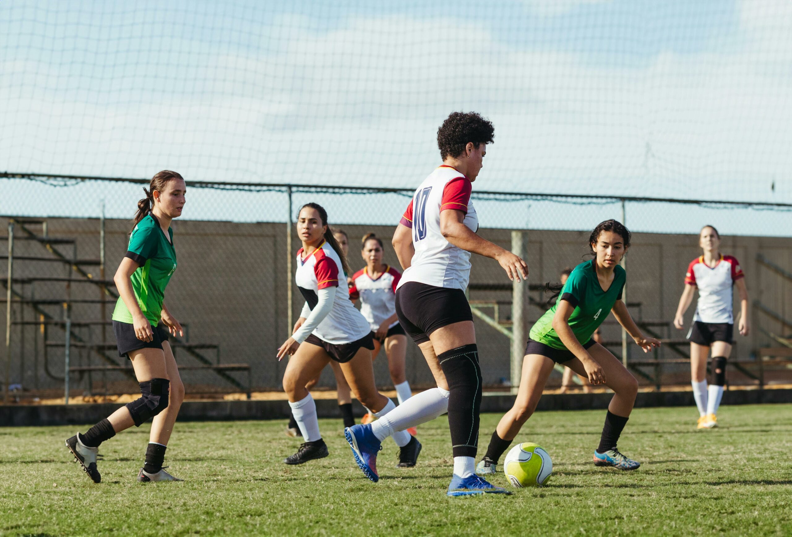 This is a photo of teenagers playing soccer on an outdoor field.