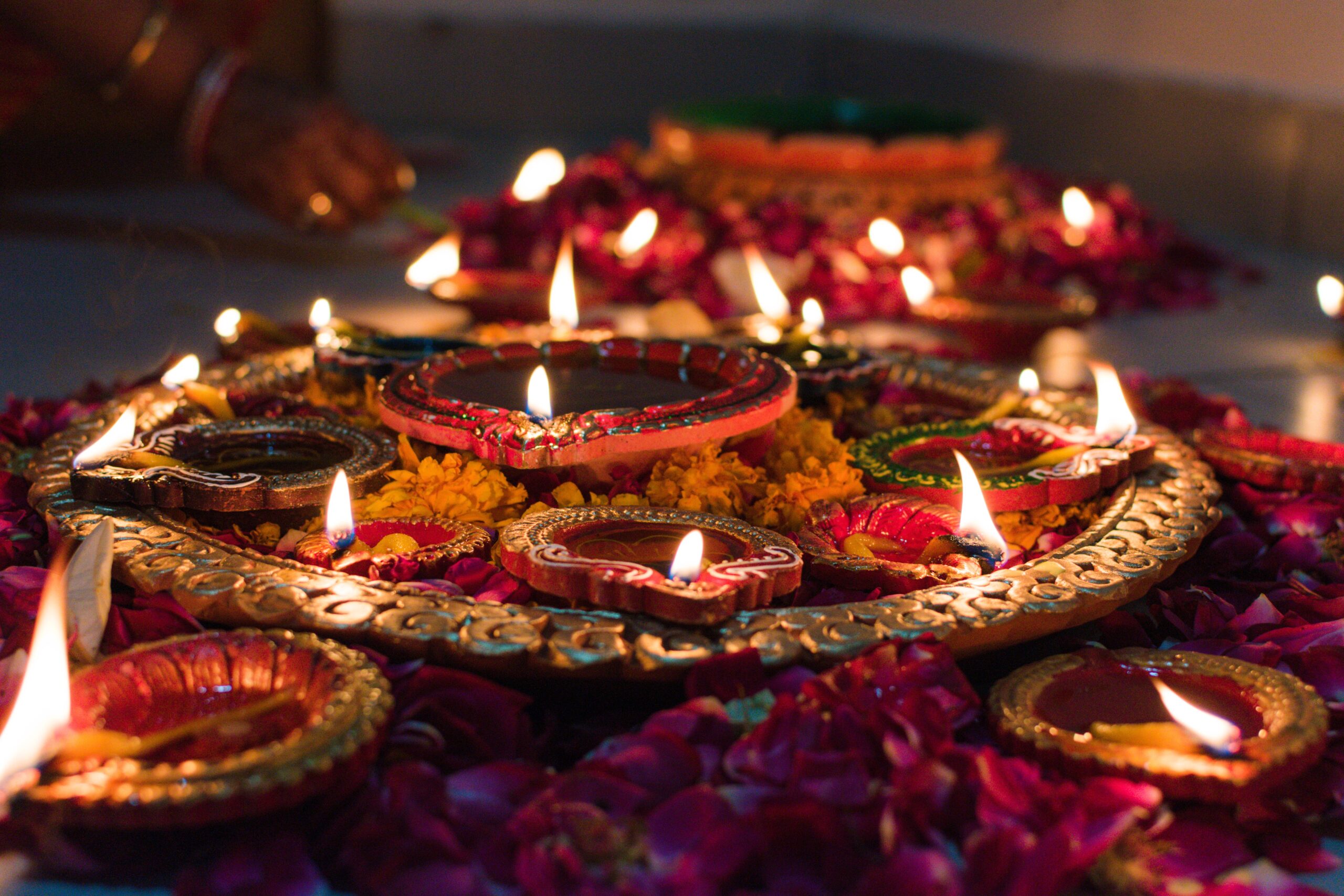 A photo of many diyas (candle holders) lit, a sea of flames for Diwali festivities.