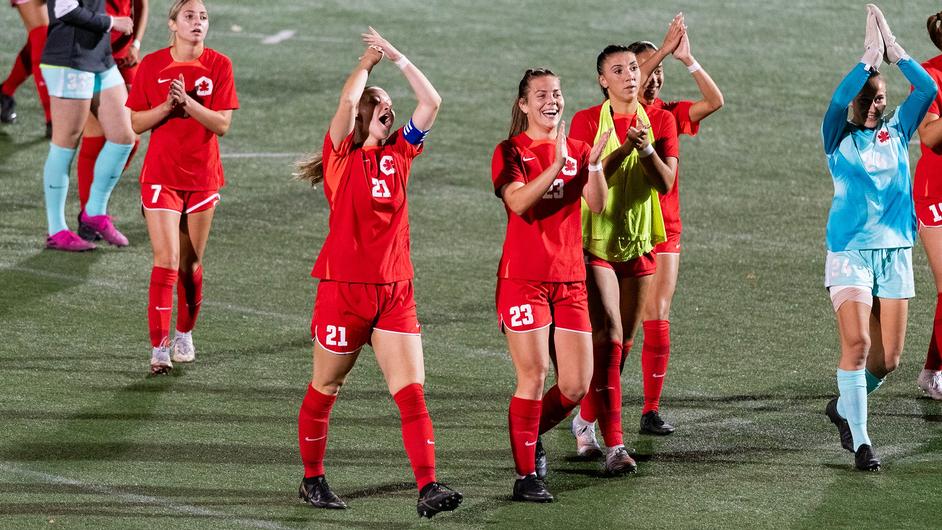 photo of the women’ soccer team clapping as they exit the field.