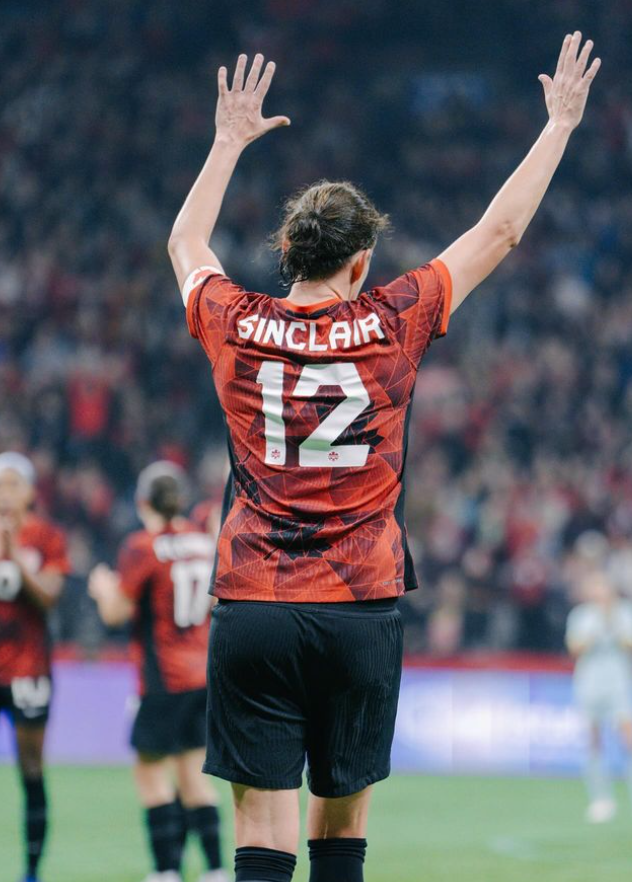 Christine Sinclair acknowledging the crowd with both her hands up.