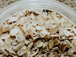 Close up of a clear plastic container filled with oats.