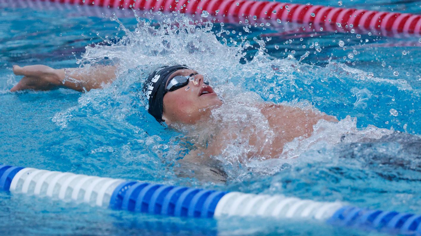 SFU swimmer competing in a backstroke event.