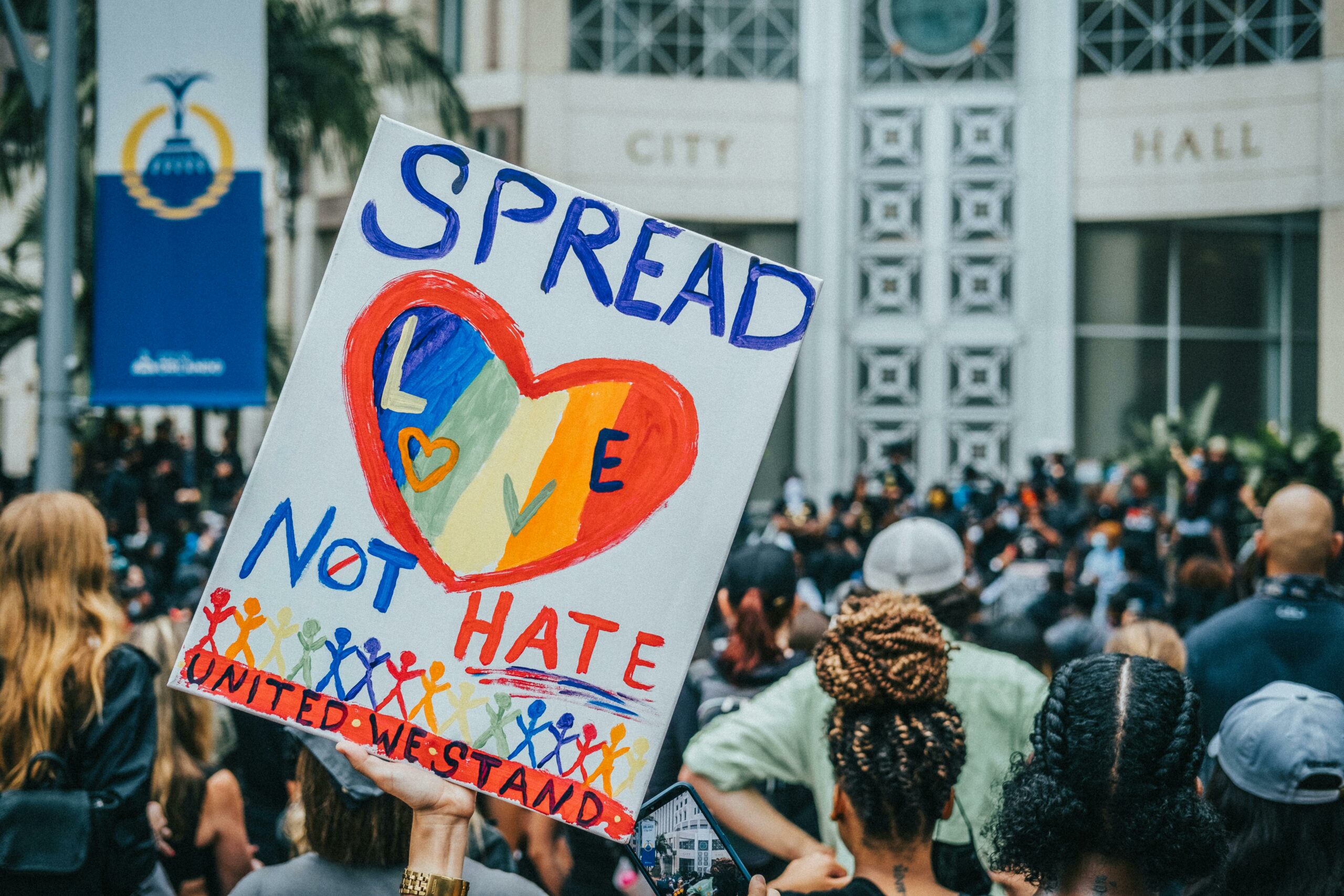 Protester holding a sign that reads Spread Love Not Hate
